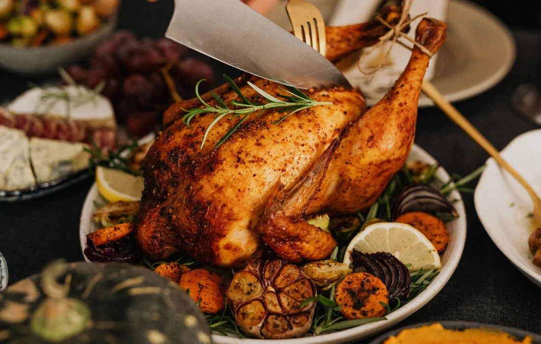 Dinde de Noël rôtie au romarin, entourée de légumes rôtis, découpée à table